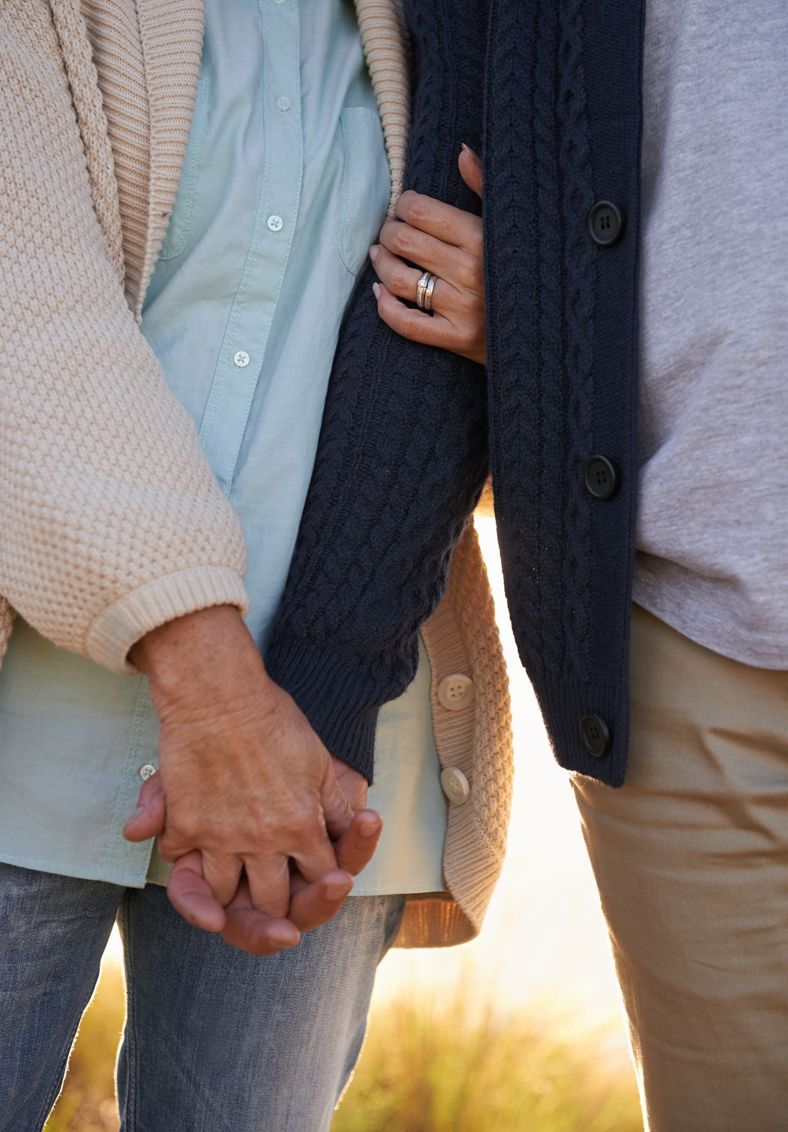 A couple holding hands outdoors at golden hour